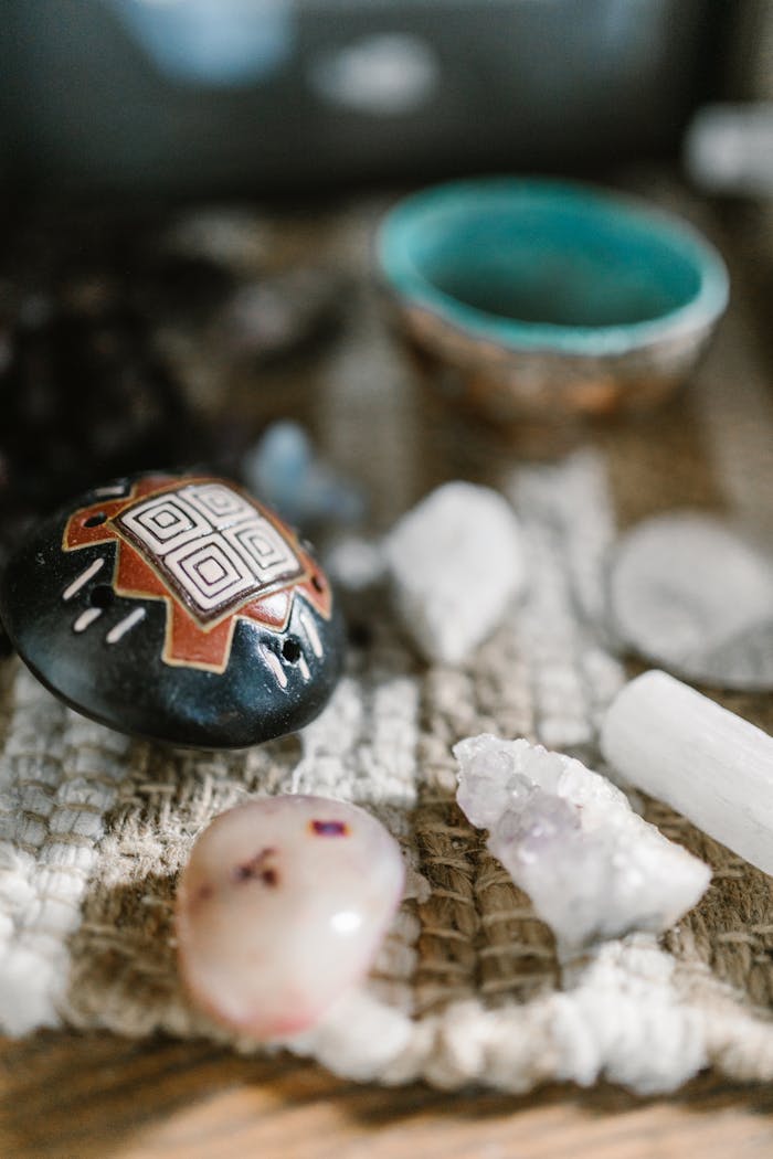 A variety of healing crystals and stones displayed on a textured mat, perfect for spiritual or meditation themes.